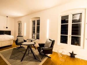 a bedroom with a bed and two chairs and a table at MiHotel Vieux Lyon in Lyon