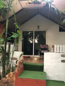 a house with a porch with a green floor at Pine Bungalow Krabi in Klong Muang Beach