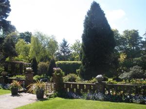 a garden with a fence and flowers and trees at Lastingham Grange in Lastingham
