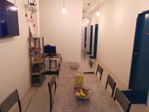 a room with a table with chairs and a bowl of bananas on it at TEMPO in Semporna