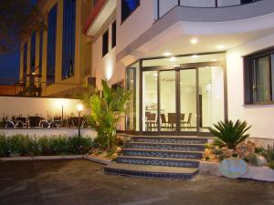 a house with a staircase in front of a building at Hotel Blanc in Casoria