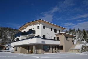 a large building in the snow with snow at fewo kramer in Heiterwang