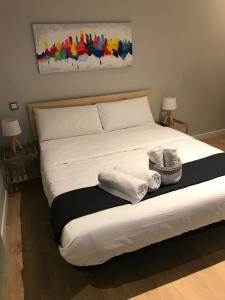 1 dormitorio con 1 cama con toallas en Marina Rooms, en Madrid