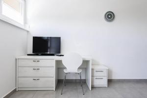 escritorio blanco con TV y silla blanca en Stylish Centre Apartments, en Zadar
