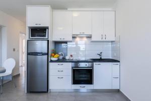 cocina con armarios blancos y nevera de acero inoxidable en Stylish Centre Apartments, en Zadar