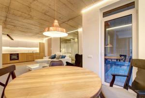 comedor y sala de estar con mesa de madera en Kauno-Algirdo Luxury apartments, en Vilna