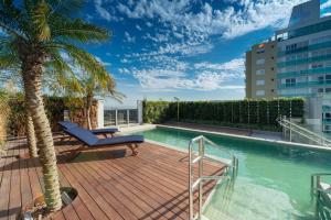 a deck with a pool on a building with a palm tree at Hotel Laghetto Stilo Higienópolis in Porto Alegre +37 photos