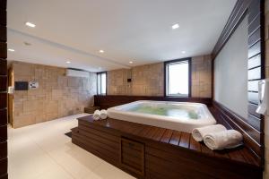a large bathroom with a large tub in it at Hotel Laghetto Stilo Higienópolis in Porto Alegre