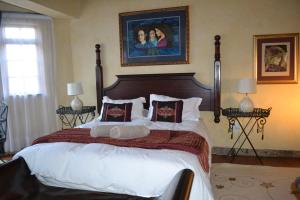 a bedroom with a large bed with white sheets and pillows at Fox & Squirrel in Dullstroom