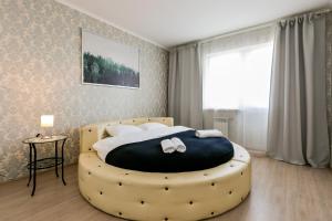 モスクワにあるGrand Apart Putilkovoのベッドルーム1室(大型ベッド1台、大型オットマン付)
