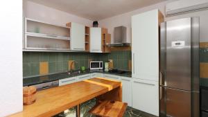 a kitchen with white cabinets and a stainless steel refrigerator at House Lipo in Makarska