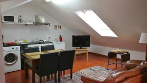 a living room with a kitchen and a table with chairs at Valmoa in Praia da Vitória