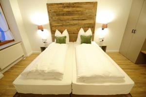 a large white bed in a room with two lamps at Aparthotel Deutscher Kaiser Ferienwohnungen in Kurort Oberwiesenthal