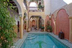 an indoor courtyard with a swimming pool in a building at Riad Itrane in Marrakesh
