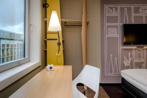 Zimmer mit einem Tisch, einem Stuhl und einem Fenster in der Unterkunft Ibis Münster City in Münster