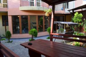 a wooden bench sitting on a patio in front of a building at хотел Европа in Shumen