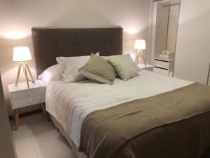 a bedroom with a large bed with two lamps at Centro de Asunción Nuevo Apartamento, Cómodo, Seguro, Piscina, Gimnasio y Parking in Asuncion +18 photos