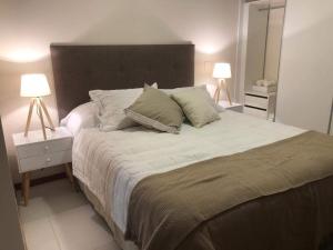 1 dormitorio con 1 cama grande y 2 lámparas en Centro de Asunción Nuevo Apartamento, Cómodo, Seguro, Piscina, Gimnasio y Parking, en Asunción