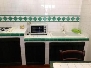 a kitchen with a microwave and a sink at 13 Via Pavone in Zafferana Etnea