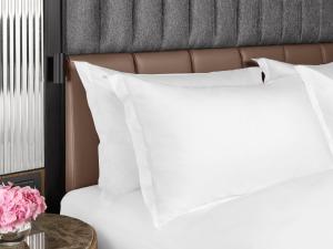 a bed with white pillows and a table with flowers at InterContinental Sofia by IHG in Sofia