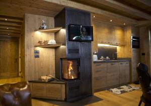 sala de estar con chimenea y TV en Haus Martina, en Sappada