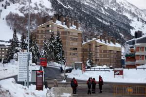 un grupo de personas de pie en la nieve cerca de un edificio en Amitges by FeelFree Rentals, en Baqueira Beret