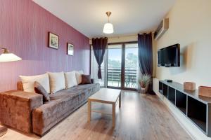 a living room with a couch and a tv at Apartamenty Apartinfo Jasny Brzeg in Władysławowo