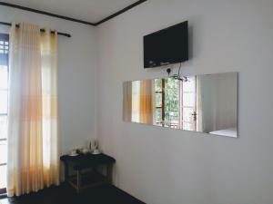 Habitación con TV en la pared y ventana. en Okeed Ella en Ella