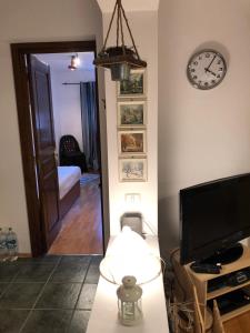 a room with a clock on the wall and a television at STILL Apartament Sinaia in Sinaia