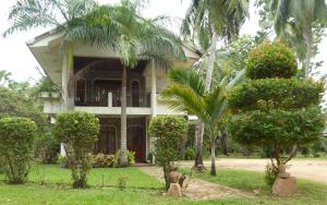 une maison avec des palmiers devant elle dans l'établissement Riviera Resort, à Batticaloa