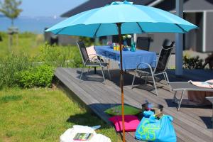 una mesa con una sombrilla azul en una cubierta en Ferienhaus Randers, en Steinbergkirche