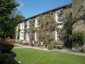 un edificio con mesas y sillas delante de él en Lastingham Grange, en Lastingham