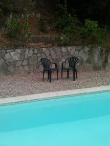 two black chairs sitting next to a rock wall at Casa Montseny con piscina,bosque in Sant Pere de Vilamajor +12 photos