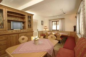 a living room with a table and chairs and a television at Ferienhaus/Chalet Schneiderhäusl in Flachau