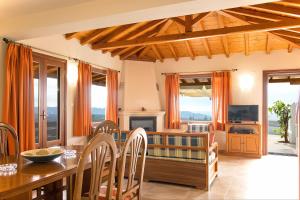 a living room with a table and chairs and a television at Armamento Villa in Skiathos