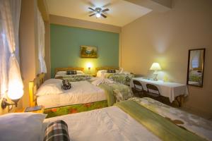 Habitación de hotel con 4 camas, mesa y lámparas en Hotel San Jorge en Santa Rosa de Copán