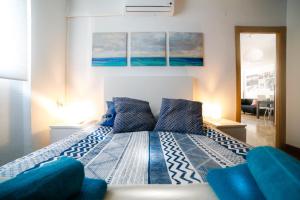 マラガにあるEl Quinto Pino Málaga Centroのベッドルーム(青い枕の大型ベッド1台付)