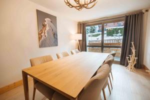 a dining room with a wooden table and chairs at Megeve Appartment – Vacances d'hiver – АЕ102 in Megève +4 photos