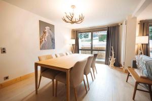 a dining room with a wooden table and chairs at Megeve Appartment – Vacances d'hiver – АЕ102 in Megève