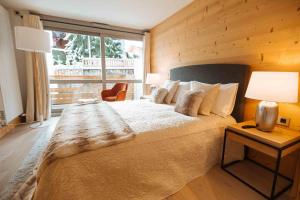 a bedroom with a large bed and a large window at Megeve Appartment – Vacances d'hiver – АЕ102 in Megève