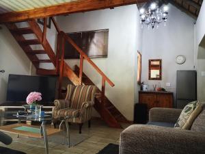 a living room with a staircase and a table and chairs at Dublin Guest House in Sabie