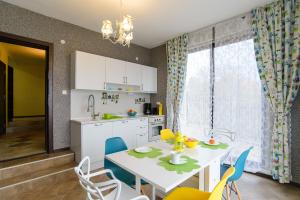 a kitchen with a white table and blue chairs at Villa Varna View in Varna City