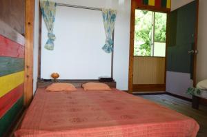 名護市にあるbackpackers guesthouse Borderのベッドルーム1室(赤いベッドカバー付)