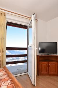 a room with a sliding glass door with a television at Vila Parang in Petroşani