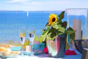 Una mesa con un jarrón con un girasol y copas de vino. en Ferienhaus Skagen, en Steinbergkirche