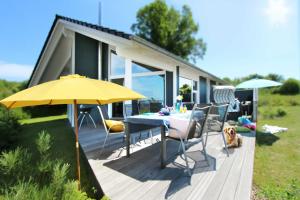 una terraza con mesa y sombrilla amarilla en Ferienhaus Randers, en Steinbergkirche