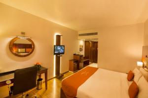 a hotel room with a bed and a television at Citrine in Bangalore