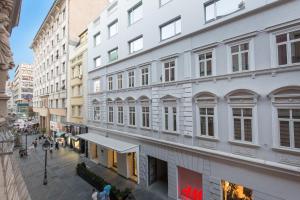a city street with buildings and people walking down it at Boutique Hotel Museum in Belgrade