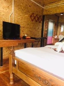Mook Tamarind Resort في كو موك: غرفة نوم بسرير وتلفزيون على طاولة