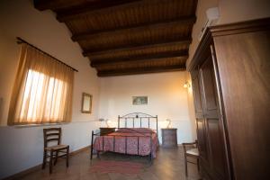 a bedroom with a bed and two chairs in it at Agriturismo Antichi Granai in Calatafimi